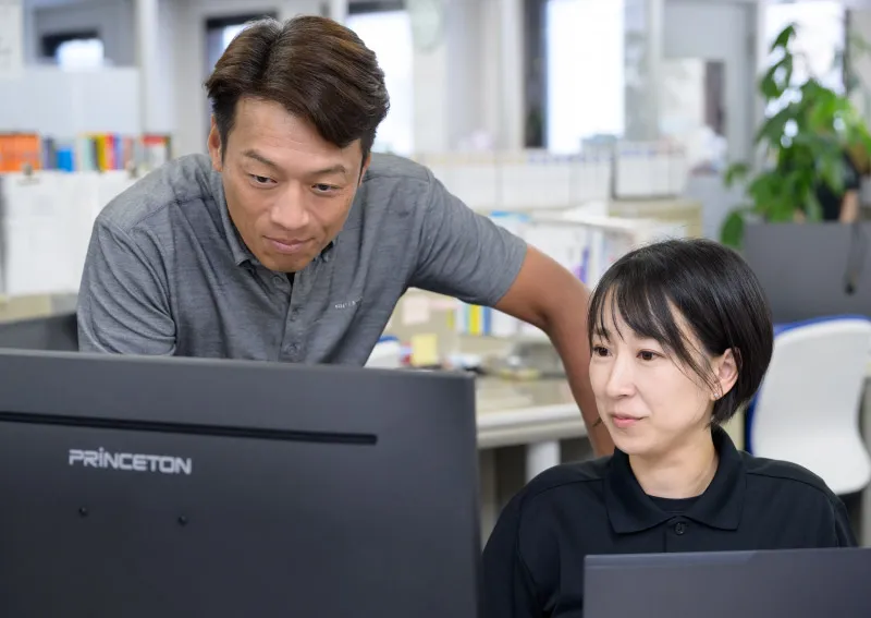 社員がオフィスで相談しあっている画像