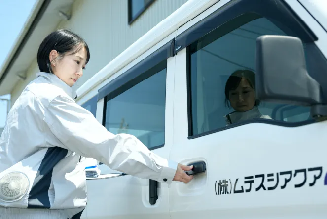 社員が社用車に乗ろうとしている画像